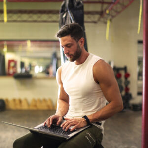 personal training sitting working on laptop, pta career pt course