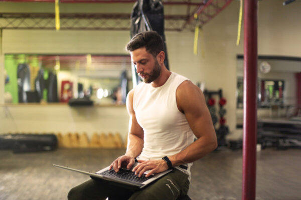 personal training sitting working on laptop, pta career pt course
